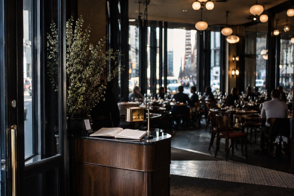 A host stand with a reservation book inside a New York restaurant entrance