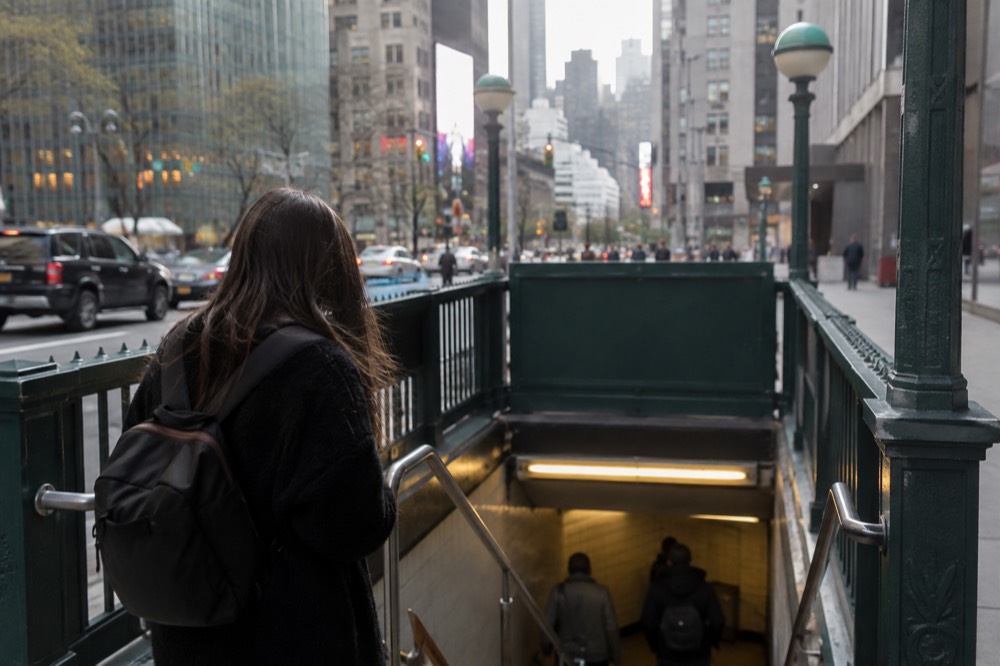 A person studying a subway map on a station wall in New York