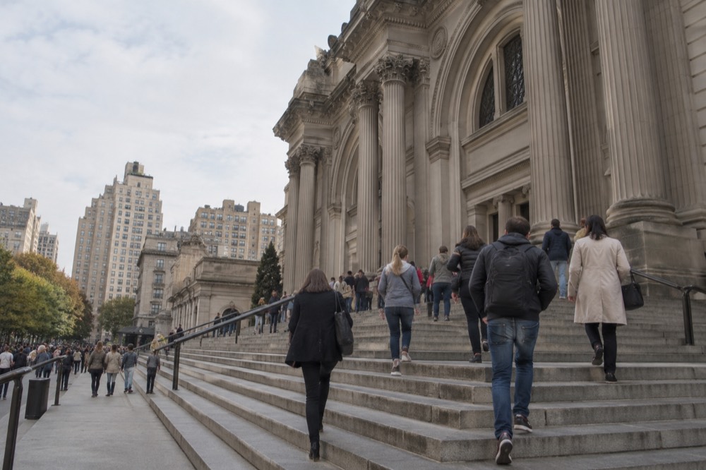 Visitors walking up the steps of the Metropolitan Museum of Art on Fifth Avenue
