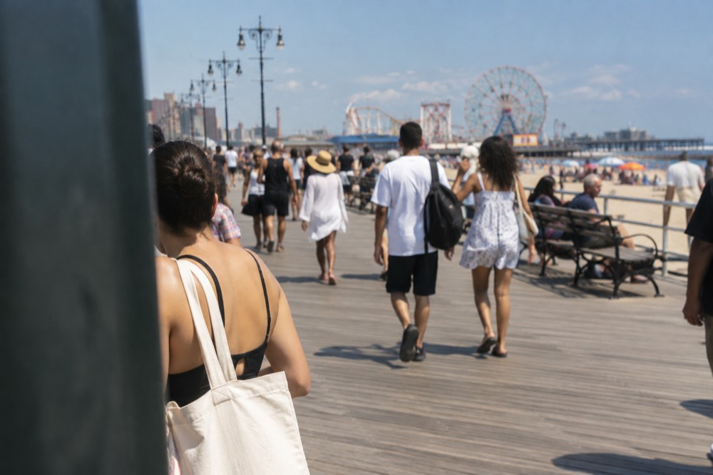 Crowded Coney Island boardwalk on a hot summer day