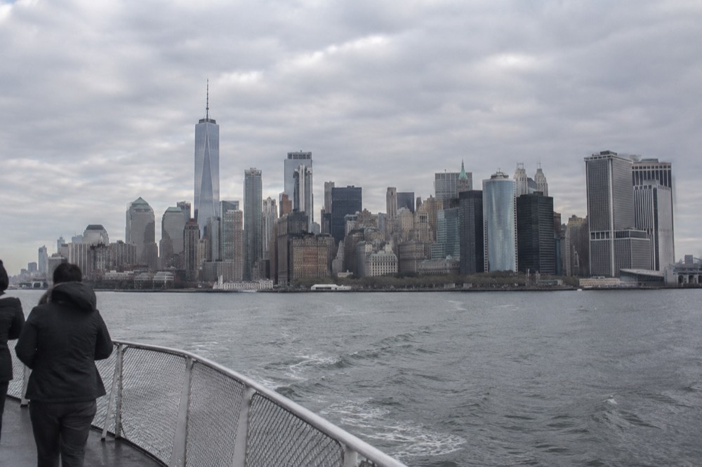 A clear morning view of the Manhattan skyline from a ferry on the harbor