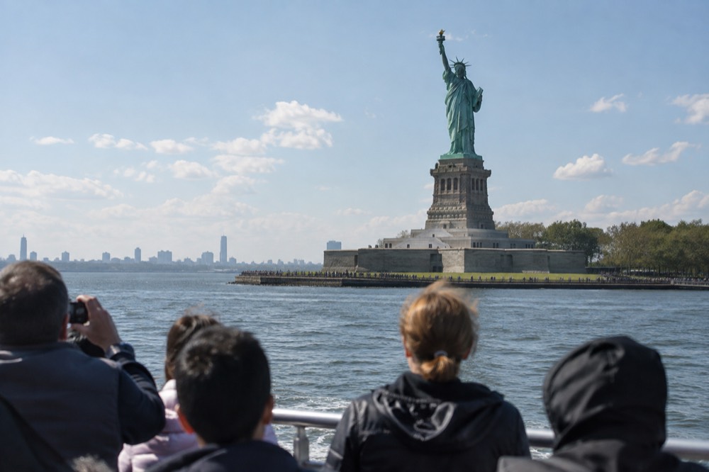 A ferry boat passing close to the Statue of Liberty in New York Harbor