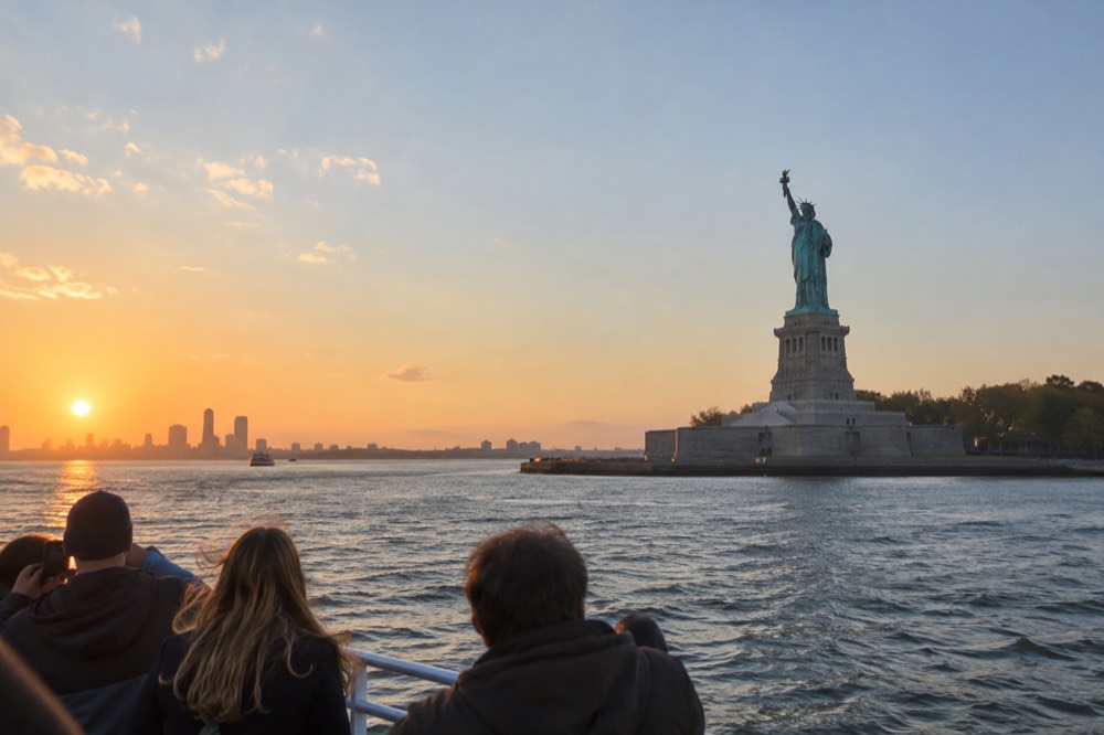 A sightseeing boat passing the Statue of Liberty in New York Harbor