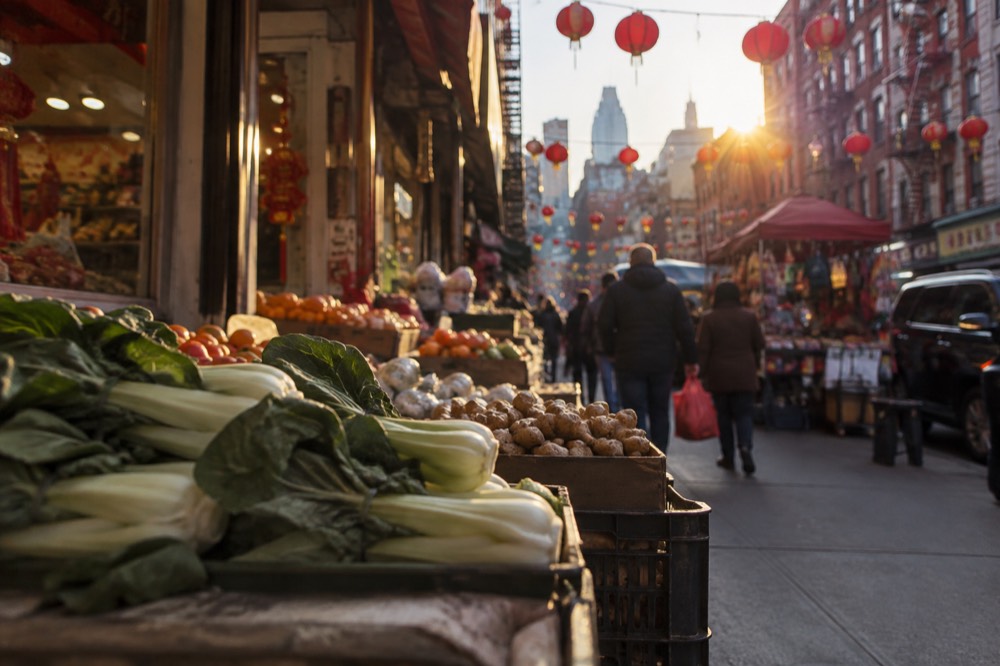 A busy street in Chinatown with market stalls and hanging shop signs