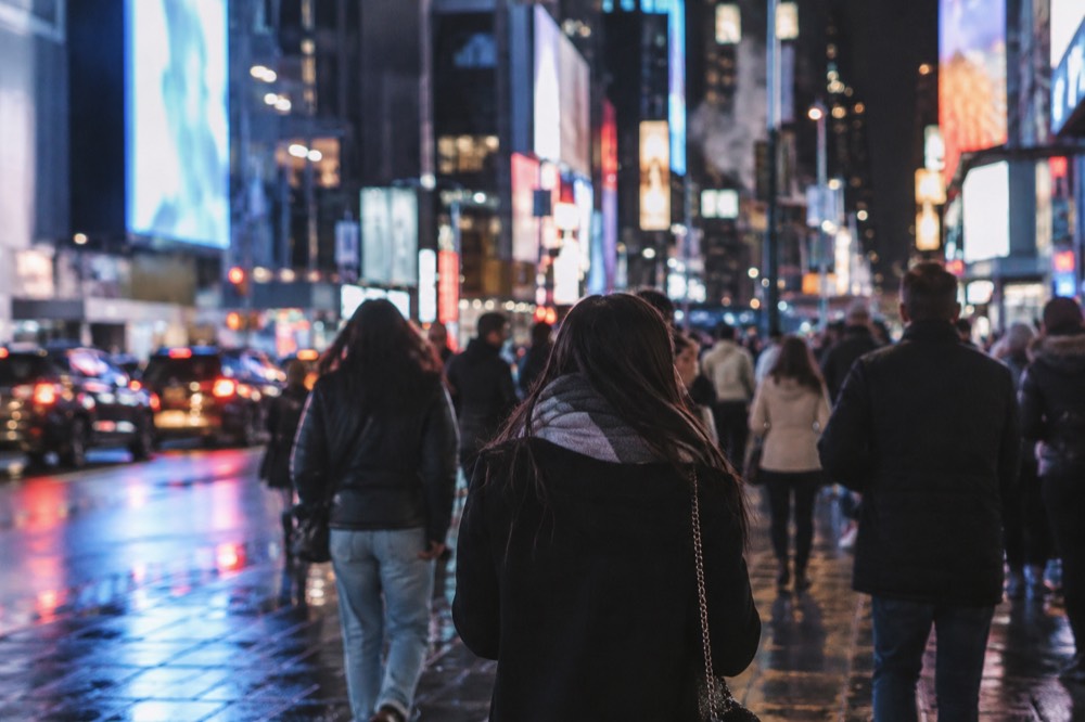 A crowded Times Square at night with billboards lighting the street