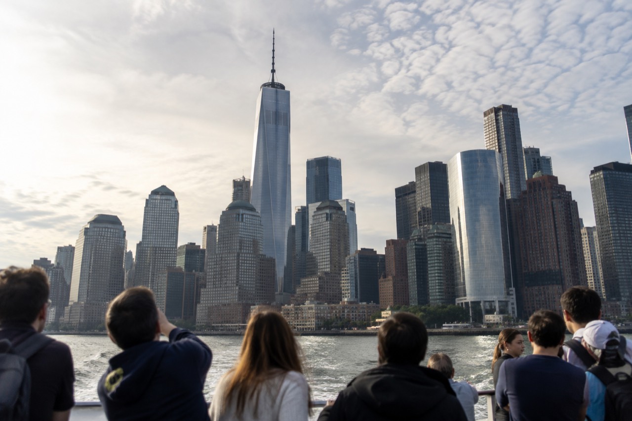 First-time visitors looking up at the Manhattan skyline from a ferry in New York Harbor