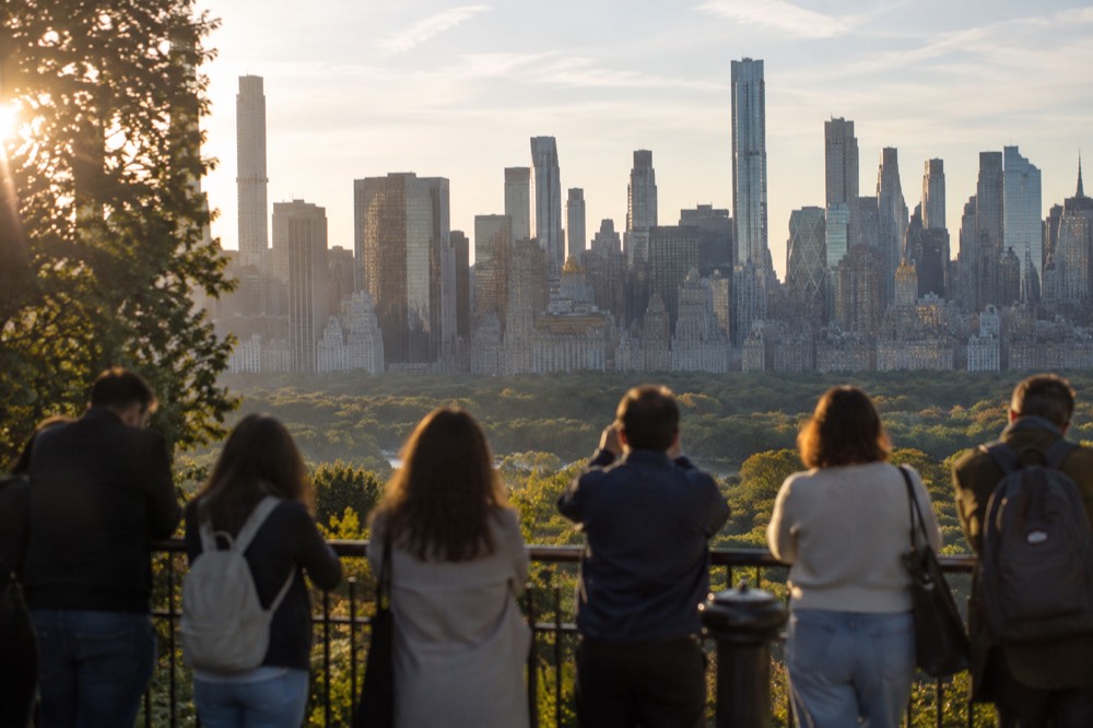 Visitors on an observation deck looking out over Central Park and the Midtown skyline