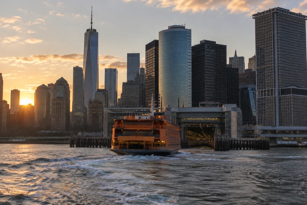 The Staten Island Ferry approaching the Manhattan terminal with the skyline behind it